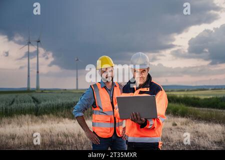 Ingenieure arbeiten zusammen an einem Laptop in einem Windpark Stockfoto