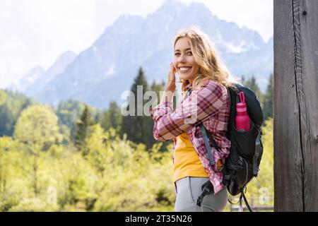 Lächelnder Backpacker vor den Bergen im Zelenci Nature Reserve Stockfoto