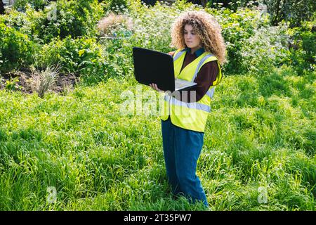 Ingenieur mit Laptop auf Gras Stockfoto