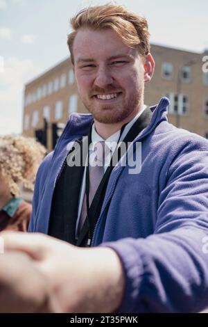 Lächelnder Geschäftsmann beim Handschlag auf der Straße Stockfoto