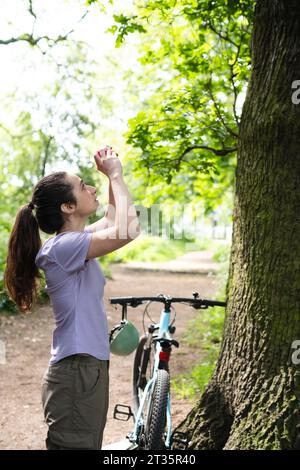 Junger Fotograf, der Baum durch die Kamera fotografiert Stockfoto