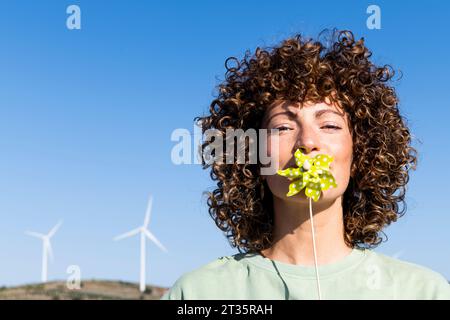 Eine Frau, die das Flitzenrad-Spielzeug über den Mund hält Stockfoto