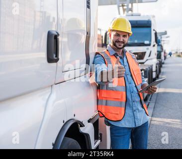 Glücklicher Lkw-Fahrer, der die Daumen nach oben zeigt Stockfoto