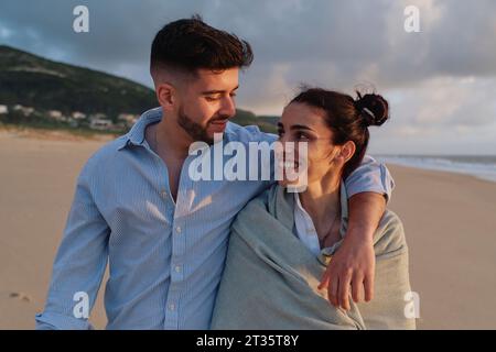 Mann mit Arm um Freundin am Strand Stockfoto