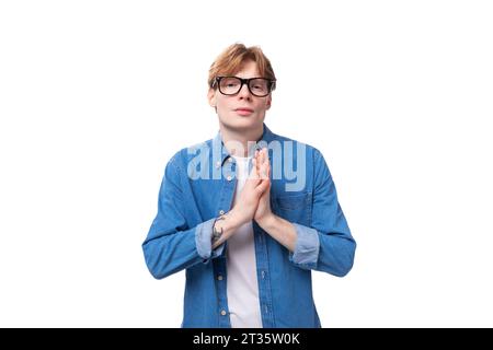 Junger, intelligenter europäischer Mann mit kupferfarbenen Haaren trägt ein Denimhemd und ist ein Brainstorming Stockfoto