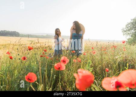 Mutter und Tochter verbringen Freizeit im Mohnfeld Stockfoto