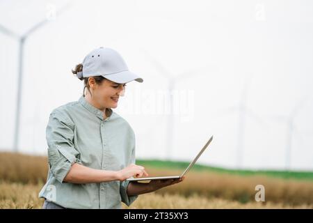 Glücklicher Agronomist, der am Laptop arbeitet Stockfoto