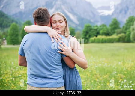 Frau mit geschlossenen Augen, die den Mann umschließt Stockfoto