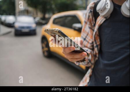 Teenager, der auf der Straße ein Smartphone benutzt Stockfoto