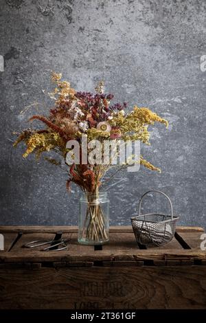 Anordnung der getrockneten Blüten im Glas auf Holzkiste Stockfoto