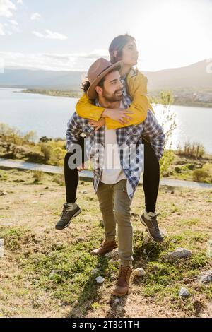Der Freund reitet mit dem Huckepack an seine Freundin Stockfoto