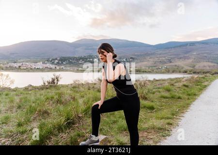 Müde Frau, die nach dem Laufen in der Nähe der Straße Pause macht Stockfoto