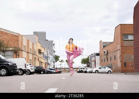 Glückliche Frau, die unter dem Himmel auf der Straße läuft Stockfoto