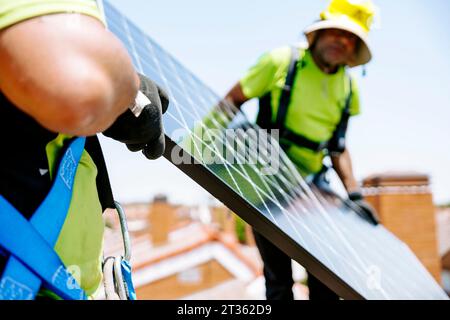 Ingenieure, die Solarpaneele auf dem Dach installieren Stockfoto