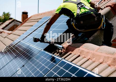 Ingenieur mit Handwerkzeug zur Installation des Solarmoduls an sonnigen Tagen Stockfoto