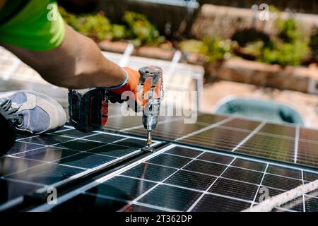 Ingenieur, der Sonnenkollektor mit Bohrmaschine installiert Stockfoto