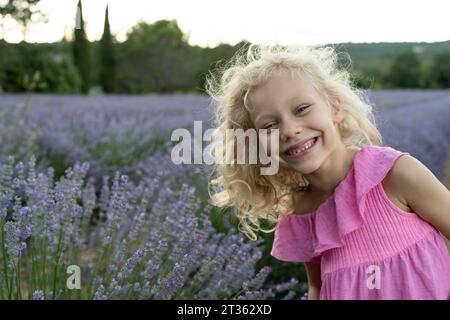 Glückliches blondes Mädchen vor dem Lavendelfeld Stockfoto