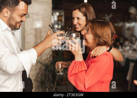 Glückliche Frau, die Weingläser mit Mann bei Hochzeitsempfang toast Stockfoto