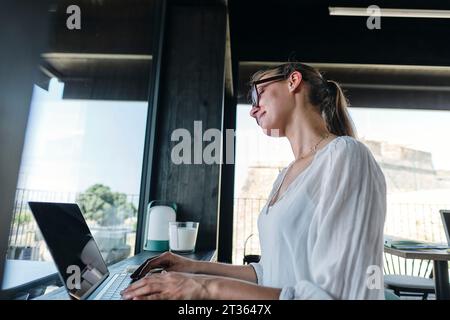 Ziemlich blond mit Laptop auf der Cafetreske Stockfoto
