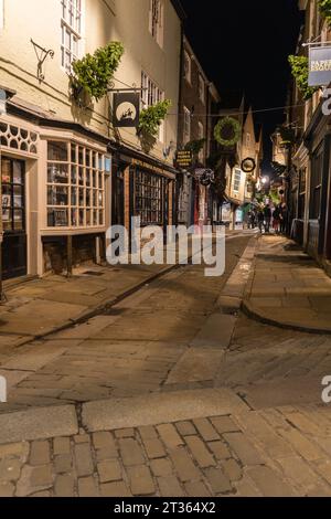 Touristen Schaufensterbummel, wenn die Nacht auf die historischen Schambles fällt, York England Großbritannien. Oktober 2023 Stockfoto