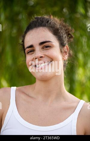 Glückliche junge, schöne Frau mit Tanktop Stockfoto