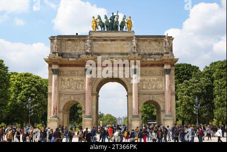 Große Gruppe von Touristen in der Nähe des Triumphbogens des Karussells (französisch: Arc de Triomphe du Carrousel). PARIS - 29. APRIL 2019 Stockfoto