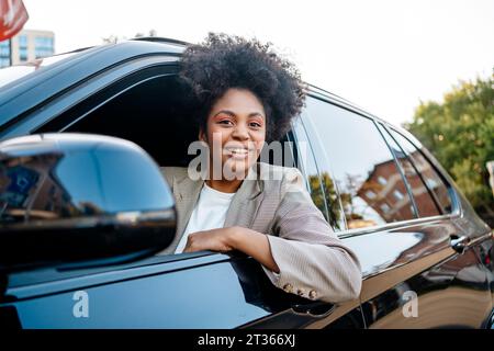 Lächelnde Geschäftsfrau sitzt im Auto Stockfoto