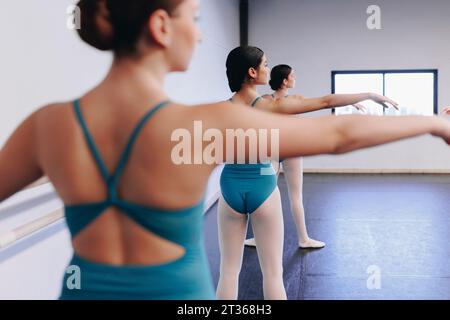 Tänzer üben Ballett mit ausgestreckten Armen in der Tanzschule Stockfoto