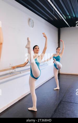 Tänzer üben Ballett, stehend auf einem Bein in der Tanzschule Stockfoto