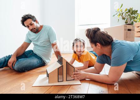 Familie spricht im Modelhaus auf dem Boden Stockfoto