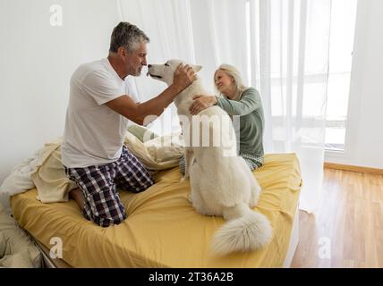 Reifes Paar, das mit Hund zu Hause spielt Stockfoto