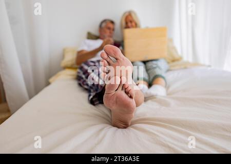 Reifes Paar, das zu Hause zusammen auf dem Bett liegt Stockfoto