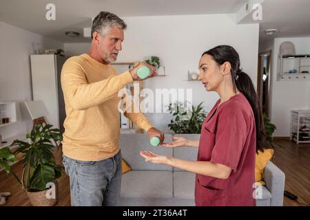Therapeutin unterrichtete Übungen für den Menschen zu Hause Stockfoto