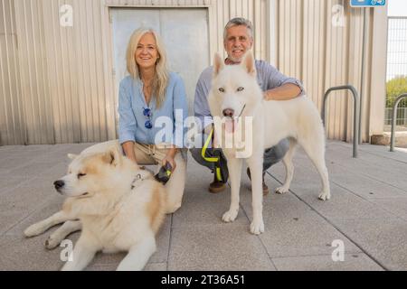 Lächelndes reifes Paar mit Hunden in der Nähe des Gebäudes Stockfoto