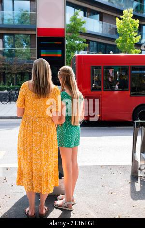 Mutter und Tochter warten an der Bushaltestelle Stockfoto