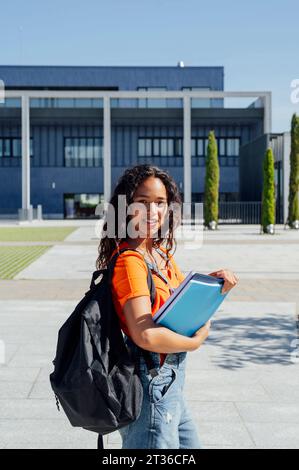 Junge Studentin mit Rucksack auf dem Campus Stockfoto