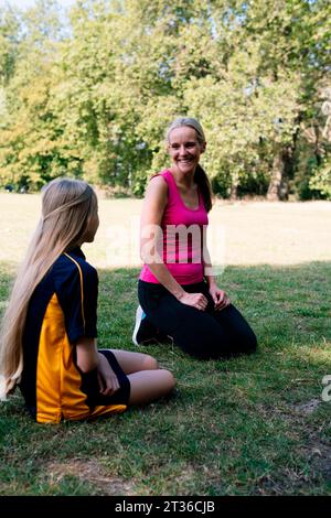 Lächelnde Mutter und Tochter reden im Park Stockfoto