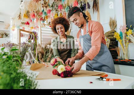 Ladenbesitzer machen Blumenstrauß am Schreibtisch Stockfoto