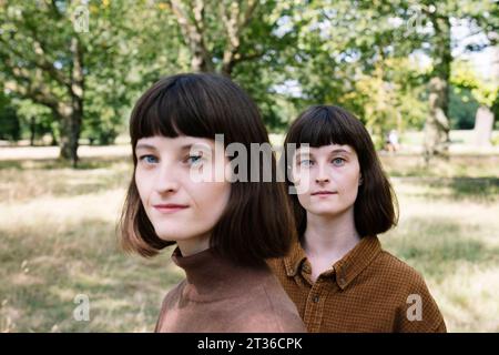 Junge Zwillingsschwestern im Park Stockfoto