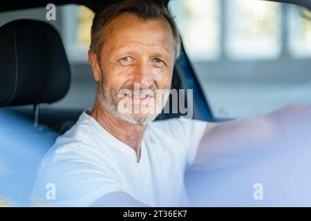 Reifer Mann sitzt im Auto Stockfoto