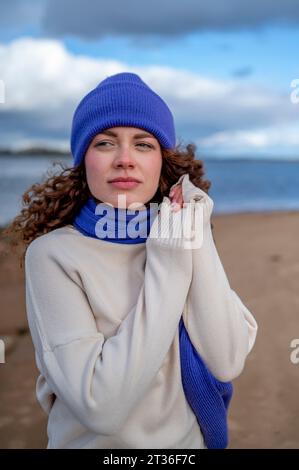 Eine junge Frau mit Strickmütze am Strand Stockfoto