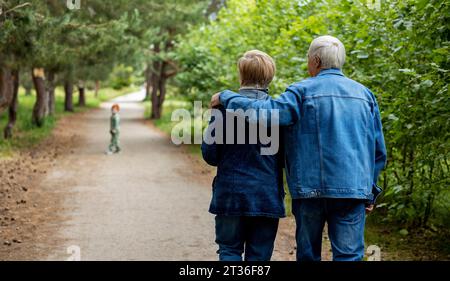 Liebevolle ältere Ehepaare, die zusammen im Wald spazieren Stockfoto