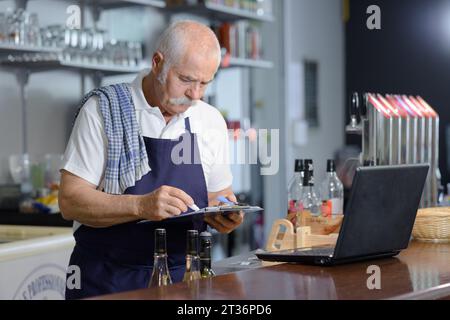Männlicher Barista, der das Tablet an der Theke verwendet Stockfoto
