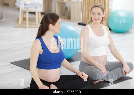 Zwei schwangere Sportmodelle machen Gymnastikübungen Stockfoto