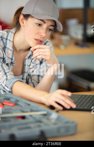 Weibliche Ingenieurin mit Laptop in einer Werkstatt Stockfoto