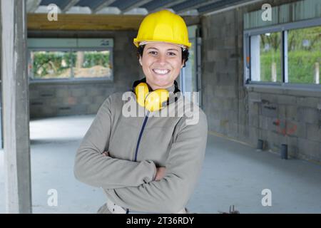 Frau mit schützenden Ohrstöpseln und Helm Stockfoto