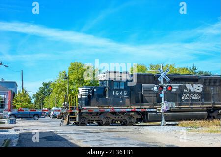 NEW ORLEANS, LA, USA – 21. OKTOBER 2023: Die Norfolk Southern-Lokomotive überquert die Chartres Street mit blinkenden Lichtern und einem Tor, das die Straße blockiert Stockfoto