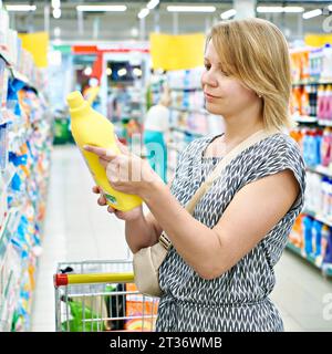 Frau wählt Reinigungsprodukte in einem Supermarkt Stockfoto