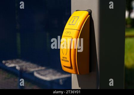 Die Taste zum Einschalten der Ampel an einem Fußgängerübergang mit der Aufschrift in Deutsch - bitte drücken. Sicherheit im Straßenverkehr. Stockfoto