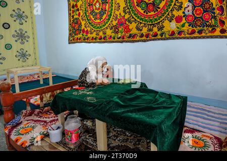 Margilan, Usbekistan - 20. Oktober 2023: Eine Frau, die in Margilan, Usbekistan, einen Wandteppich aus Seide herstellt. Stockfoto